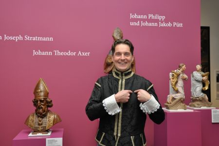 zusehen ist der GEbärdendolmetscher, der die Geste für "Willkommen" zeigt